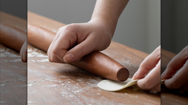 Wooden rolling pin rolling dough