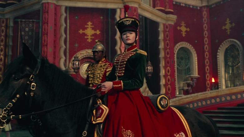 Clara riding a horse with Phillip behind her